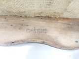 a close up of a wooden shoe on a white surface