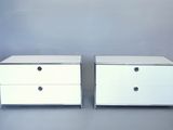 deux commodes blanches, flanquées de tiroirs de chaque côté, sur un fond gris