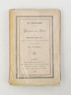 un vieux livre posé sur une table à côté d'un mur blanc