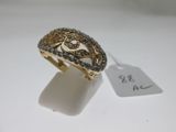 gros plan d'une bague en or avec des diamants sur une surface blanche