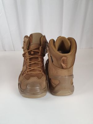 two pairs of brown hiking boots sitting on a white surface