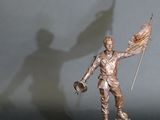 a statue of a man holding a flag and a flag pole