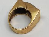 gros plan d'une bague en or sur une surface blanche