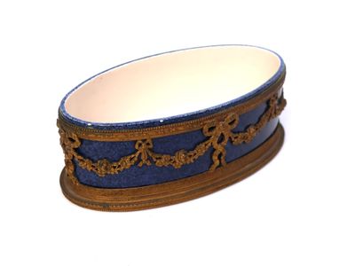 a blue and gold bowl on a stand on a white surface