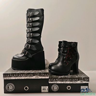 two pairs of black boots sitting on top of a box
