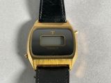 a close up of a black and gold watch on a white surface