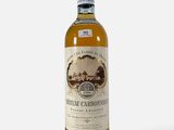 une bouteille de vin blanc posée sur une surface blanche