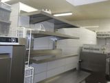 étagères dans une cuisine professionnelle équipée d'un lave-vaisselle et d'un lave-vaisselle