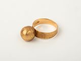 a close up of a gold ring with a ball on it