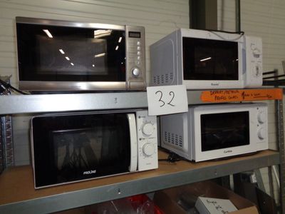 trois micro-ondes posés sur une étagère dans un magasin
