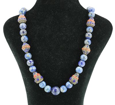 un collier composé de perles de verre bleues, présenté sur un mannequin noir