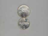 a close up of two coins sitting on top of a white surface