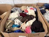 a cardboard box full of clothes and clothes sitting on the floor
