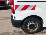 a white van with red and white stripes parked in a parking lot
