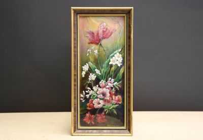 tableau représentant des fleurs, dans un cadre doré, posé sur une table