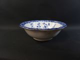 blue and white bowl sitting on a black counter top next to a microwave