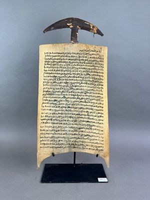 un morceau de parchemin sur lequel est posé un couteau