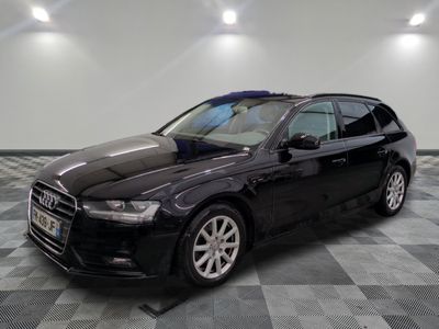 a black audi is parked on a checkered floor in a garage