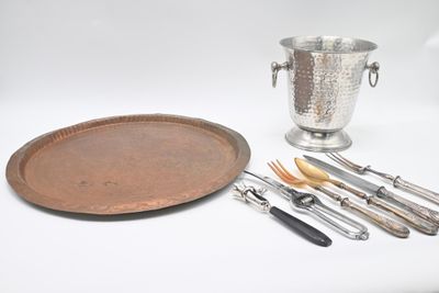 un plateau en argent et des couverts en argent posés sur une table blanche