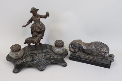 deux figurines en bronze représentant une femme et un chien, posées sur une table