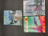 four books on a black table with a black background