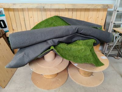 un tas d'herbe verte posé sur des bobines en bois