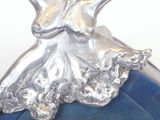 a silver sculpture of a ballerina on top of a blue ball