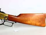 an old rifle with a wooden barrel and brass fittings