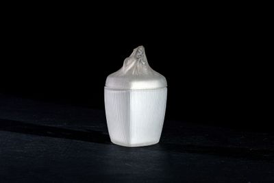 a small white cup with a lid on a table