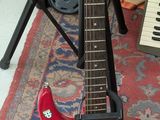 une guitare posée sur un support dans une pièce