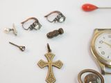 a clock, watch, earrings, and a cross on a table