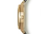 the back of a gold and black watch on a white surface