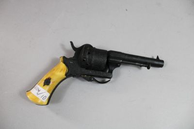 un pistolet jouet posé sur une table, avec une étiquette dessus