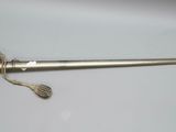 a silver sword on a white surface with a rope around it