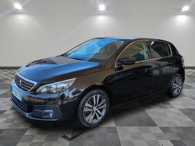 une voiture noire est garée dans une pièce au sol en damier