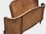 a wicker bed with a wooden frame and headboard