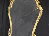 an antique gold framed mirror on a black background