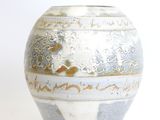 a white and blue vase sitting on a white surface