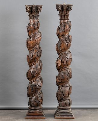 pair of carved wooden columns with carvings on each side