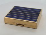 an image of a gold and blue cigarette case on a white surface