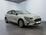 a grey ford focus is parked in a white room