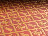 a close up of a red and gold table cloth