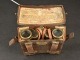 an old box with a pair of binoculars inside of it