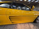 a yellow sports car parked inside of a building