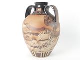 a vase with a painting on it sitting on a table