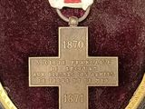 an image of a medal with a red cross on it in a case