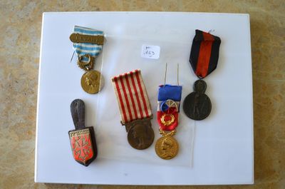 un plateau blanc sur lequel sont disposées des médailles et des insignes