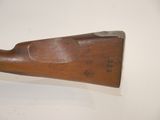 an old wooden rifle with a metal handle on a white surface