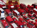 a lot of toy firetrucks and trucks on the table