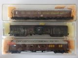 trois petits trains sont rangés dans des boîtes en plastique posées sur une surface blanche